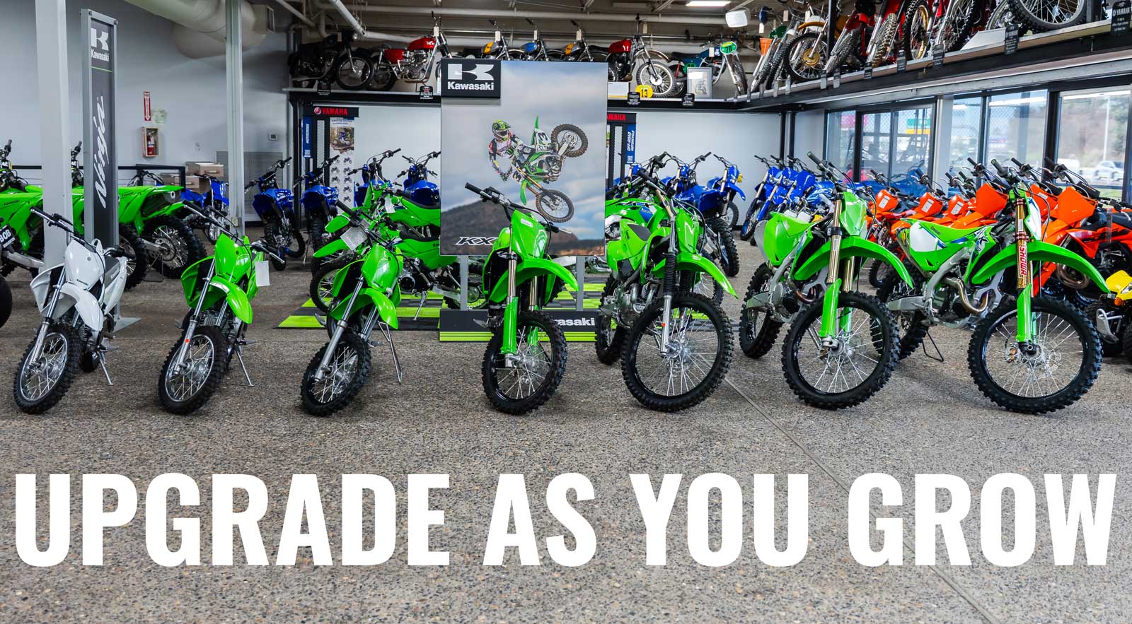 Kawasaki dirt bike lineup with Upgrade as you grow text. Beaverton Motorcycles Upgrade Promise